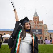 Graduating student celebrating in front of Tivoli building