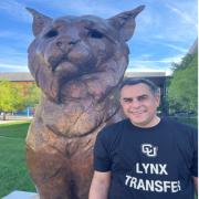 Ali Alnazzal standing in front of CU Denver's lynx statue