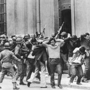 black and white picture of young chilean men being surrounded and arrested by military police