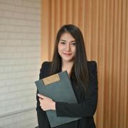 Woman at law school holding a clipboard, smiling