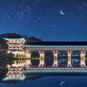 Traditional architecture Korean bridge over river at nighttime, brightly lit with stars in the sky