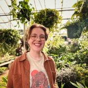 Donalyn White smiles with many plants in the backgrou d