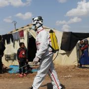 Members of the Syrian Civil defence sanitize the Bab Al-Nour internally displaced persons camp, to prevent the spread of coronavirus disease (COVID-19) in Azaz, Syria on 26 March.