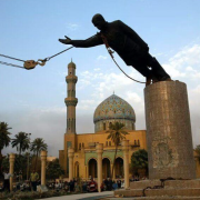 Statue of Saddam Hussein, former leader of Iraq, being pulled off its pedestal by a strong rope and pulley