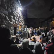 Picture of group of people watching theatrical performance of professor as turn-of-the-century Irish miner