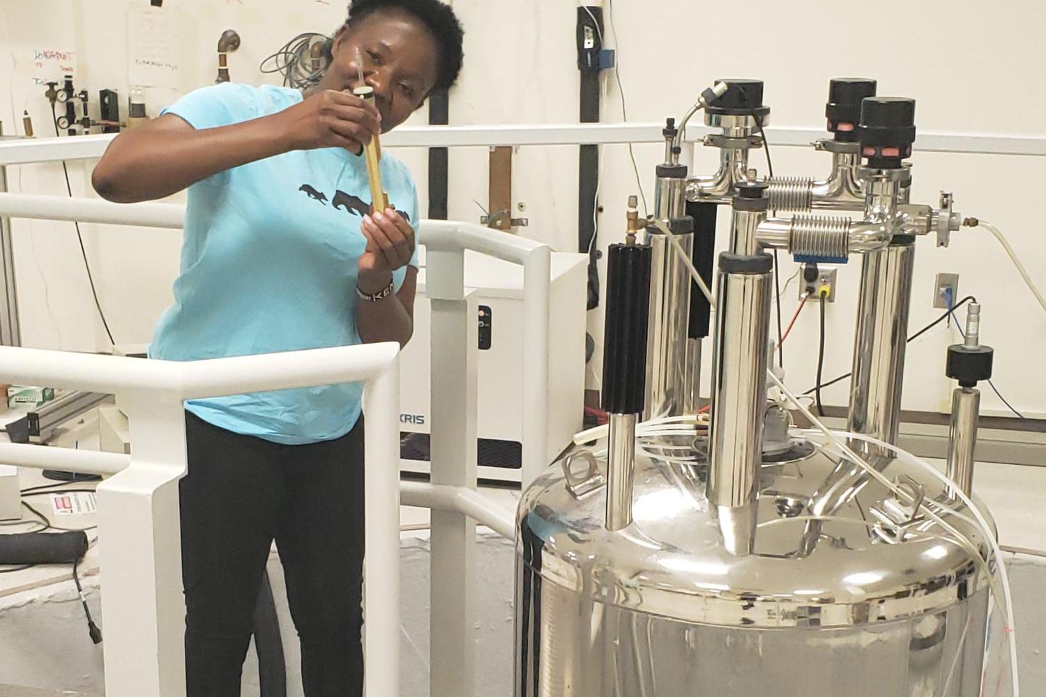2021 Fellow putting a sample in the NMR spectrometer