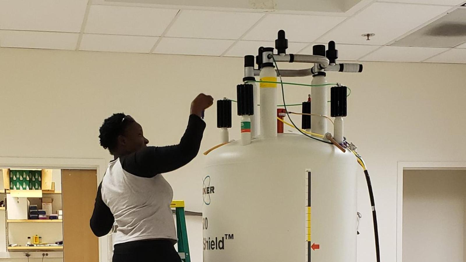 2021 participant places a sample into the high field NMR spectrometer