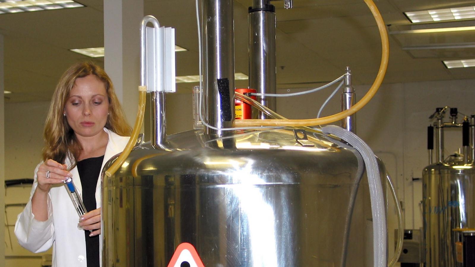 Female scientist by an NMR instrument