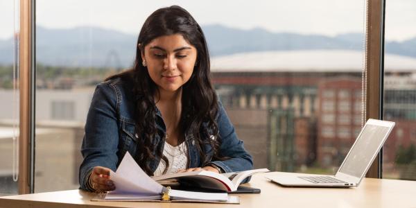 woman studying with laptop and books