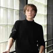 James Amidei stands in front of window