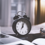 clock on desk with laptop