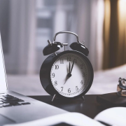 clock on desk with laptop