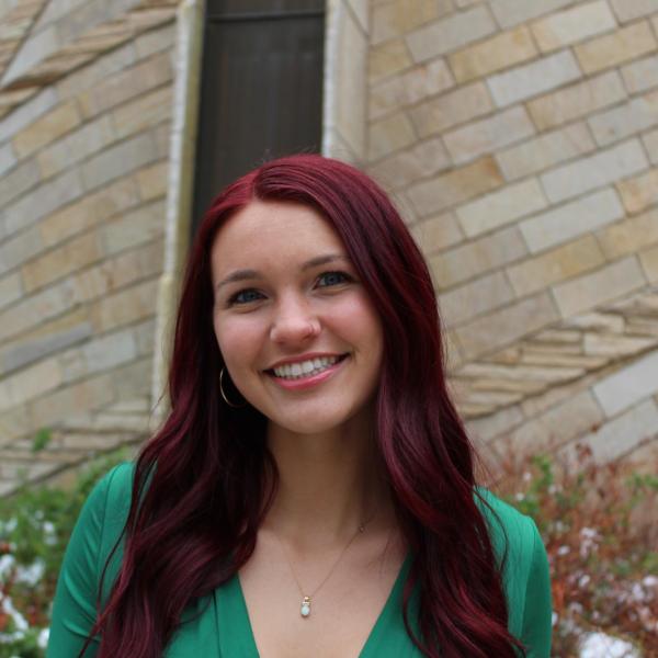 Alyssa smiling in front of a brick building