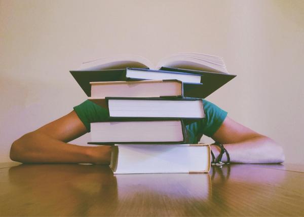 person with stack of books