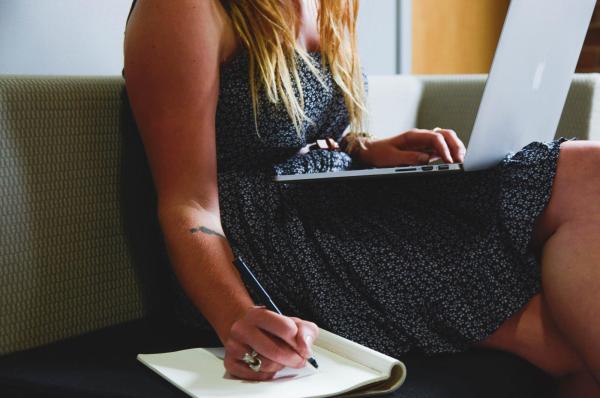 person writing with computer