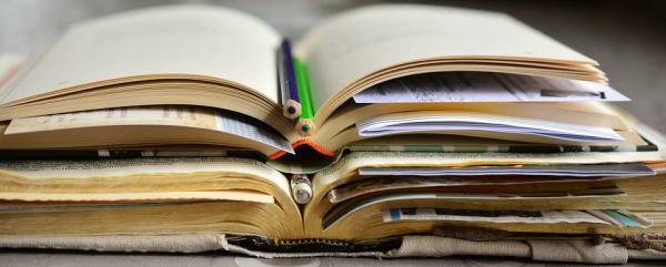 image of stack of books with pencil on top