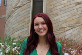 Alyssa smiling in front of a brick building